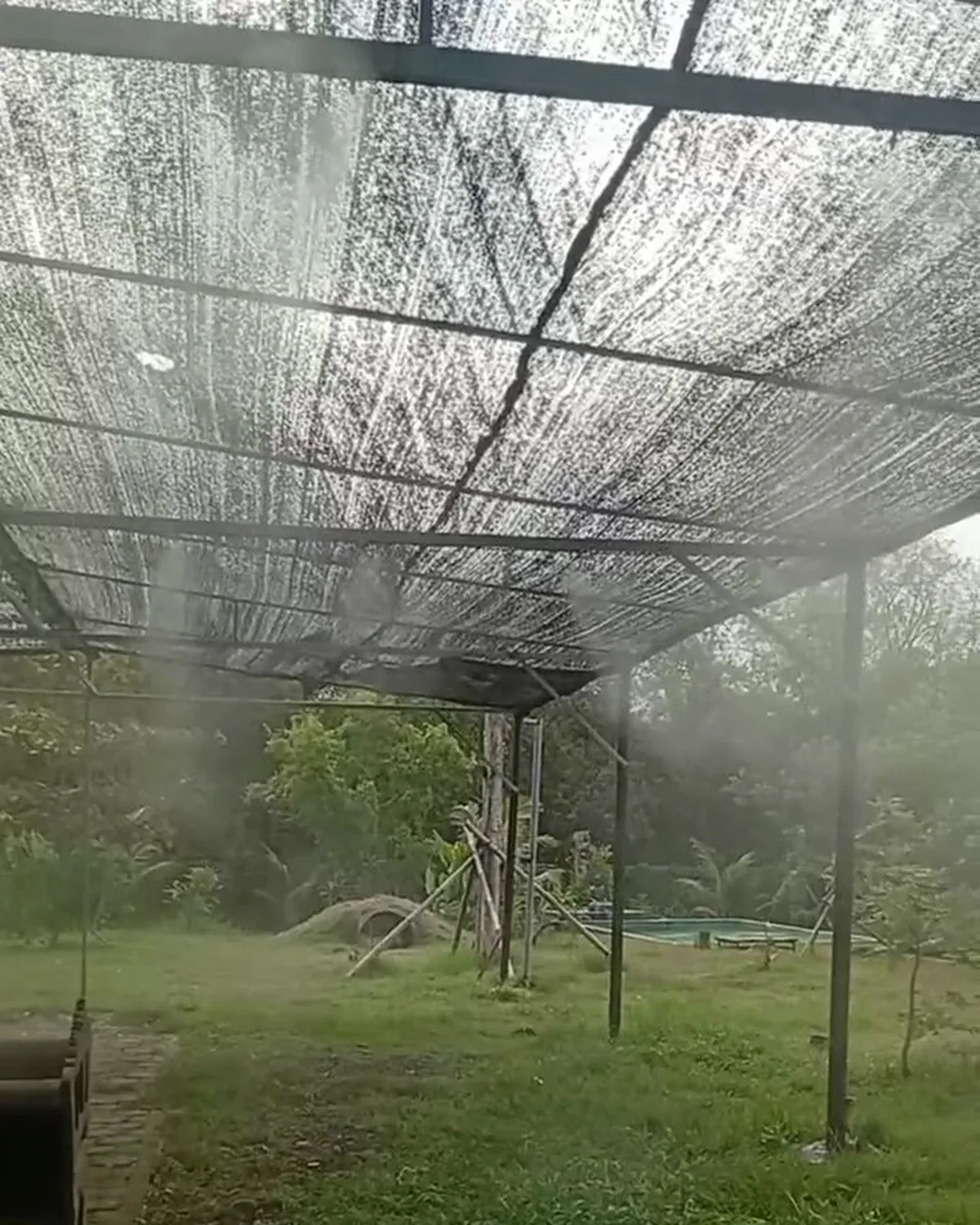 Mist working under the shade netting of an animal area