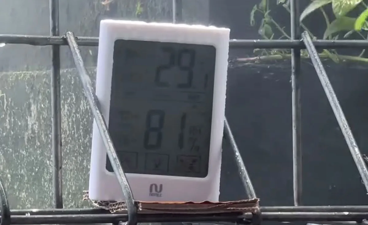 A thermometer reading 29.1°C at 81% humidity beside a working misting system