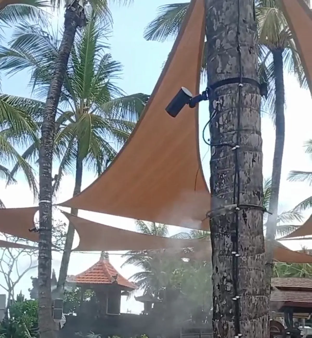 Mist under the shade sails between palms on the W Bali beachfront